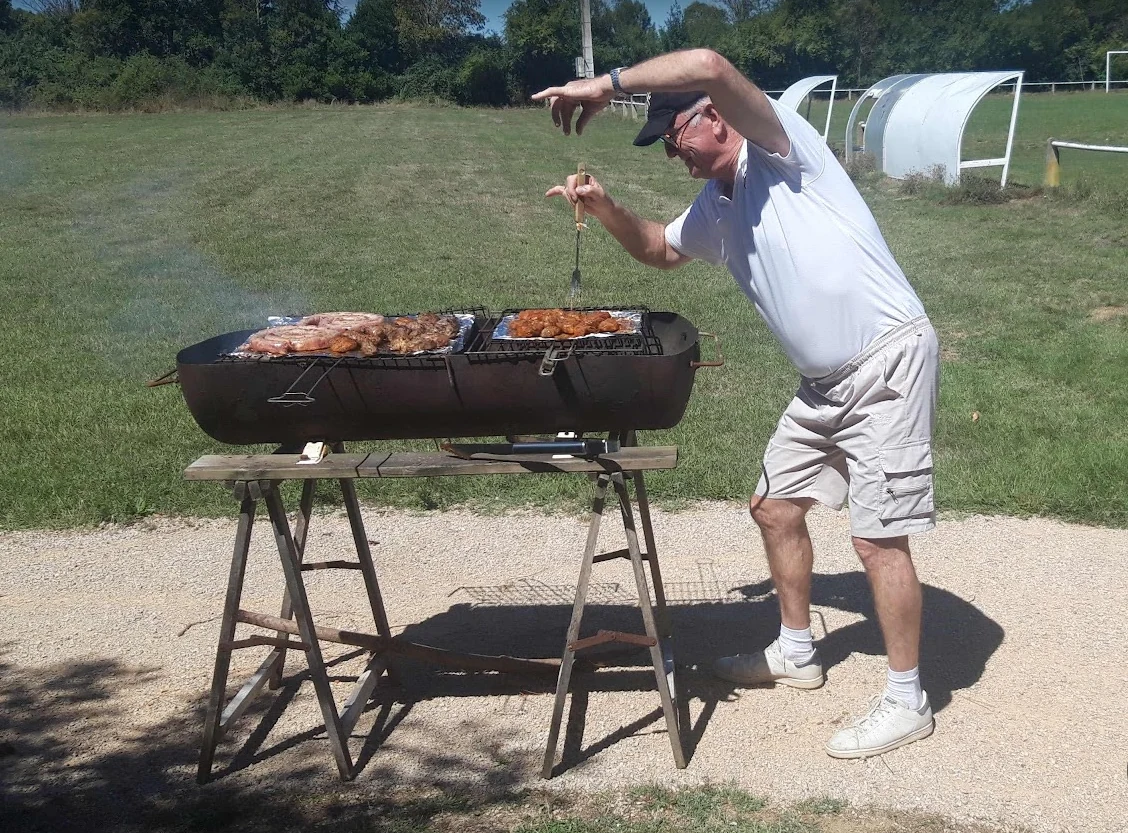 Jeannot préparant les grillades pendant la fête ACFA 2026